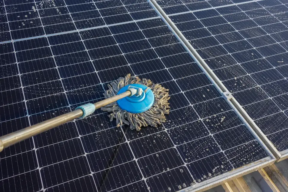 Solar panel being cleaned with a soft mop