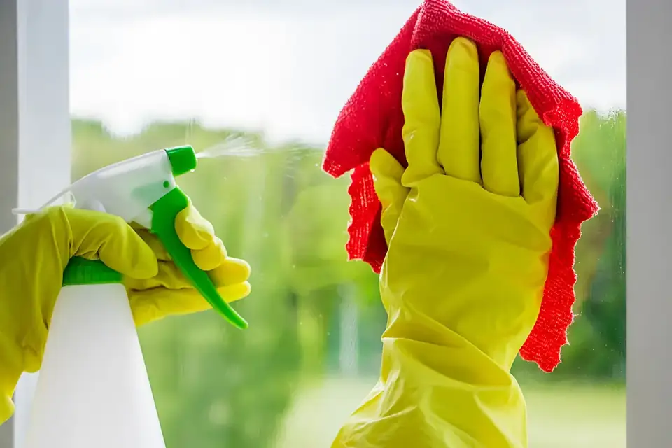 Window being cleaned with spray and cloth